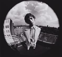 a man standing on top of a roof next to a tall building