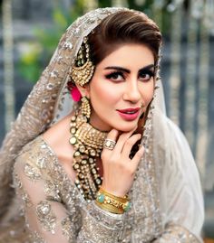 a woman in a bridal outfit posing for the camera