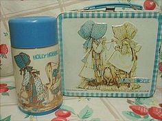 two tins sitting on top of a table next to each other with designs on them