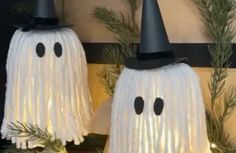 two halloween decorations made to look like ghostes with black hats and fringes on them