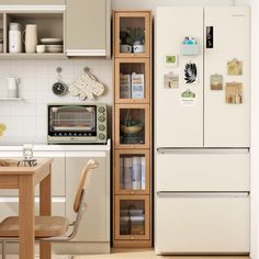 a white refrigerator freezer sitting next to a wooden table in a kitchen with lots of cupboards