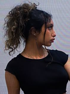 a woman holding a cell phone up to her ear and looking off into the distance