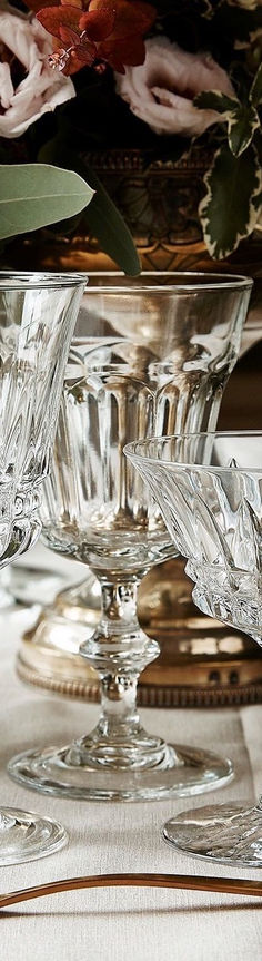 an ornate glass bowl with flowers in the background