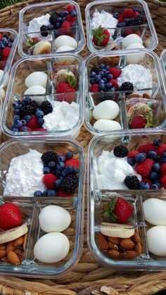 four plastic containers filled with food on top of a wooden table next to a wicker basket