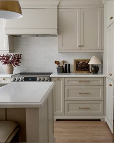 a kitchen with white cabinets and wood floors