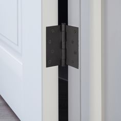 an open door with two black hinges on each side and one white hinge in the middle