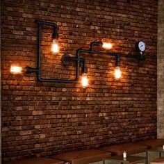 a brick wall with lights on it and some benches in front of it, along with two tables