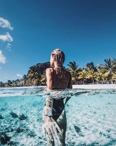 a woman is standing in the water with her arm wrapped around her body and head