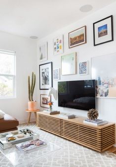 a living room with pictures on the wall and a television in the corner, along with other items