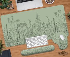 a desk with a keyboard, mouse and plants on the table next to some laptops