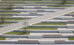 an aerial view of a concrete park with benches and grass growing on the top level