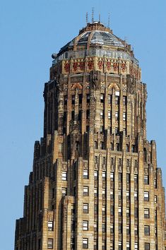 a very tall building with a clock on it's face in front of a blue sky