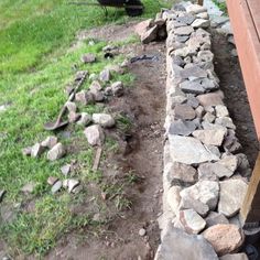 a pile of rocks sitting next to a wooden bench on top of a grass covered field