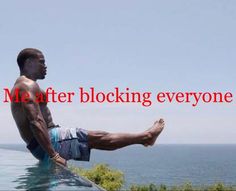 a man sitting on top of a swimming pool next to the ocean with his feet up