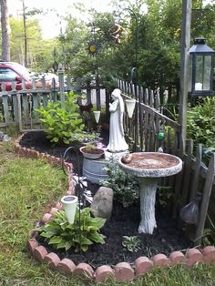 an outdoor garden with a statue and potted plants