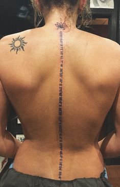 the back of a woman's neck with words written on it and sun in the background