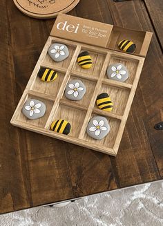 a wooden table topped with magnets covered in bees