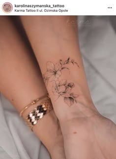 two women's feet with tattoos on them, one is holding the other hand