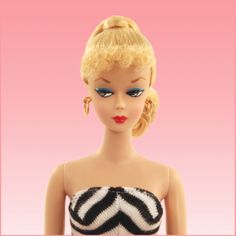 a doll with blonde hair and blue eyes wearing a black and white striped tube top