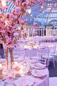 the tables are set with pink flowers and place settings