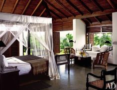 a bedroom with a canopy bed and two chairs