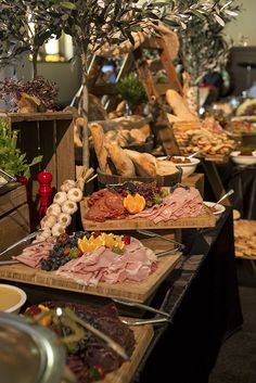 an assortment of meats and breads on display at a buffet