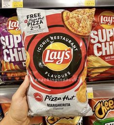 a hand holding a bag of lay's pizza chips