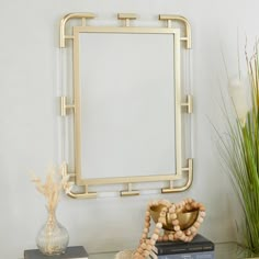 a mirror sitting on top of a wooden table next to a vase and other items