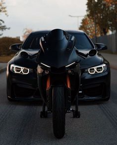 two black cars driving down the road next to each other