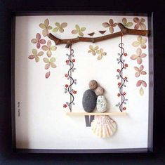 a shadow box frame with two rocks and a tree branch