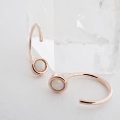 Threader hoop earrings dotted with a tiny opal. Wear these beauties solo or alongside your favorite studs or hoops. 1/2" tall. Our materials make for an amazing, high quality, seamless, jewelry piece with longevity. Our earrings are plated with 18k gold, 18k rose gold, or rhodium and finished with a protective coating. A little secret we’ll keep between us: it looks way more than it costs.