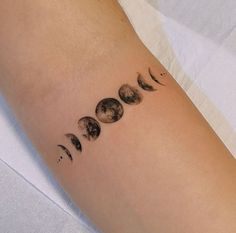 a woman's arm with phases of the moon on it