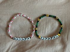 two beaded bracelets sitting on top of a bed