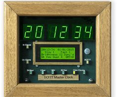 an electronic clock with green numbers in a wooden frame