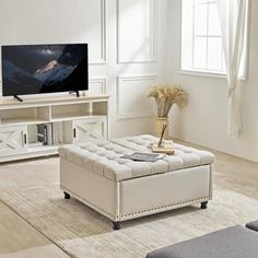 a living room with a couch, coffee table and television on the stand in front of it