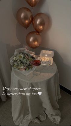 a table with some balloons and flowers on it