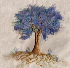 a blue tree with its roots exposed on a piece of cloth that has been stitched together