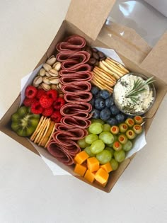 a box filled with assorted snacks and crackers on top of a white table