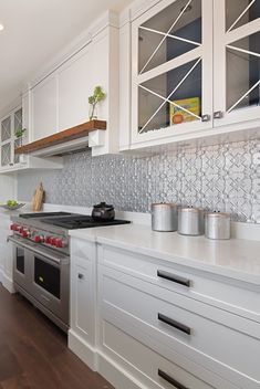 a kitchen with white cabinets and stainless steel appliances