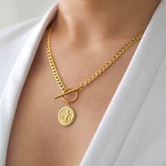 This necklace features a  Greek medallion, made after the coin depicting Athena on one side and Alexander the Great on the other. The chain is a sturdy 4mm thick chain made of 18K gold plated surgical steel, which features a deeper, more saturated yellow than 14K gold filled items. The medallion is made of 18K gold plated sterling silver. Both chain and medallion are tarnish resistant, nickel and lead-free! Medallion measures approximately 1.6 cm in diameter. Model is wearing the 18 inches. With Coin Necklace Gold, Gold Coin Necklace, Greek Coins, Heavy Chain, Toggle Necklace, Initial Necklace Gold, Alexander The Great, Gold Coin, Coin Jewelry