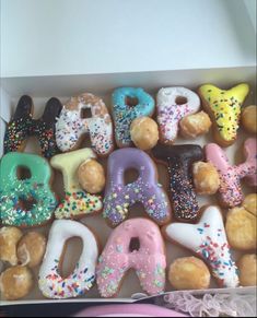 a box filled with lots of donuts covered in sprinkles and frosting