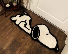 a dog rug is on the floor in front of a door with a black and white design