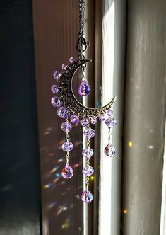 the sun shines brightly through the window with beads hanging from it's side