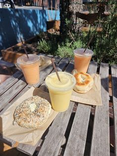 an outdoor table with drinks, bagels and doughnuts