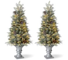 two tall christmas trees with pine cones and lights