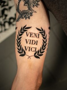 a man with a tattoo on his leg that says venti vidi vicci