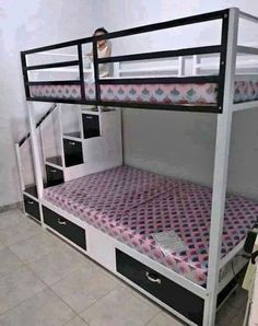 a bunk bed with drawers underneath it in a room that has tile flooring and white walls