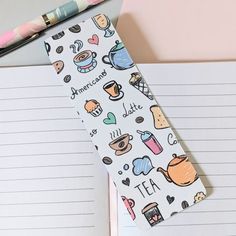 a notepad with tea related stickers on it next to a pen and notebook