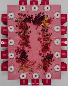 the table is covered with red and white plates, napkins, and flower arrangements