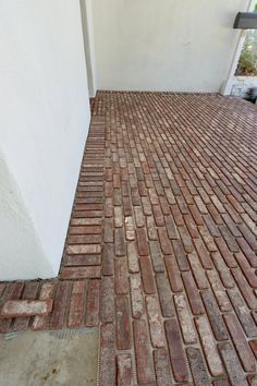 a red brick sidewalk next to a white building